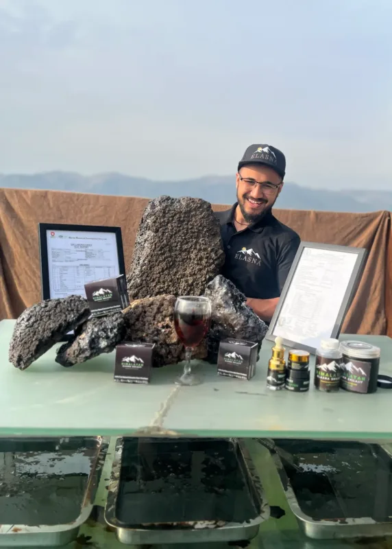 Elasna Himalayan Shilajit resin with team member showcasing raw extract and finished premium products