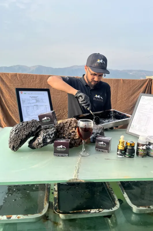 Elasna Himalayan Shilajit resin and products displayed on table with purity testing and processing setup